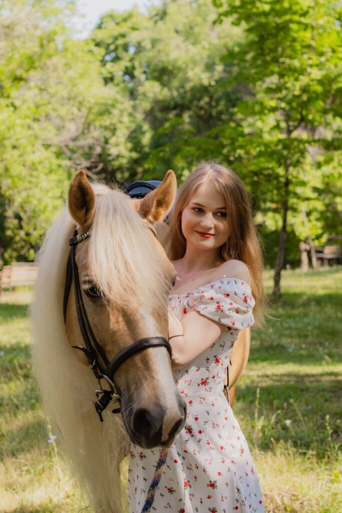 Young Woman Holding the Bridle of a Saddled Horse